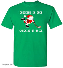 Green t-shirt with Santa Claus playing hockey and text 'Checking it once, checking it twice' on a white background.