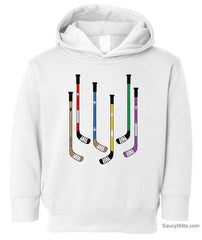 A white toddler pullover hoodie featuring a graphic print of six hockey sticks in various colors on the front.