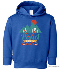 A royal blue toddler pullover hoodie featuring a graphic design on the chest with mountains, pine trees, a sun, crossed hockey sticks, and the text 'Pond Hockey'.